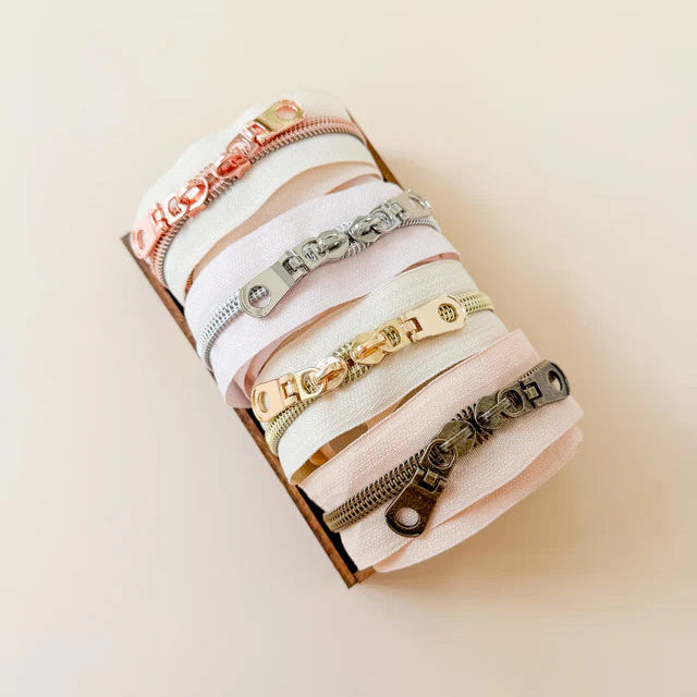 Collection of zippers on a beige background