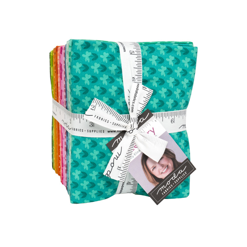 Stack of colorful fabric squares tied with a measuring tape ribbon, featuring floral patterns from Elizabeth Hartman's Scenery Fabric Collection for modern needlework and quilting projects.