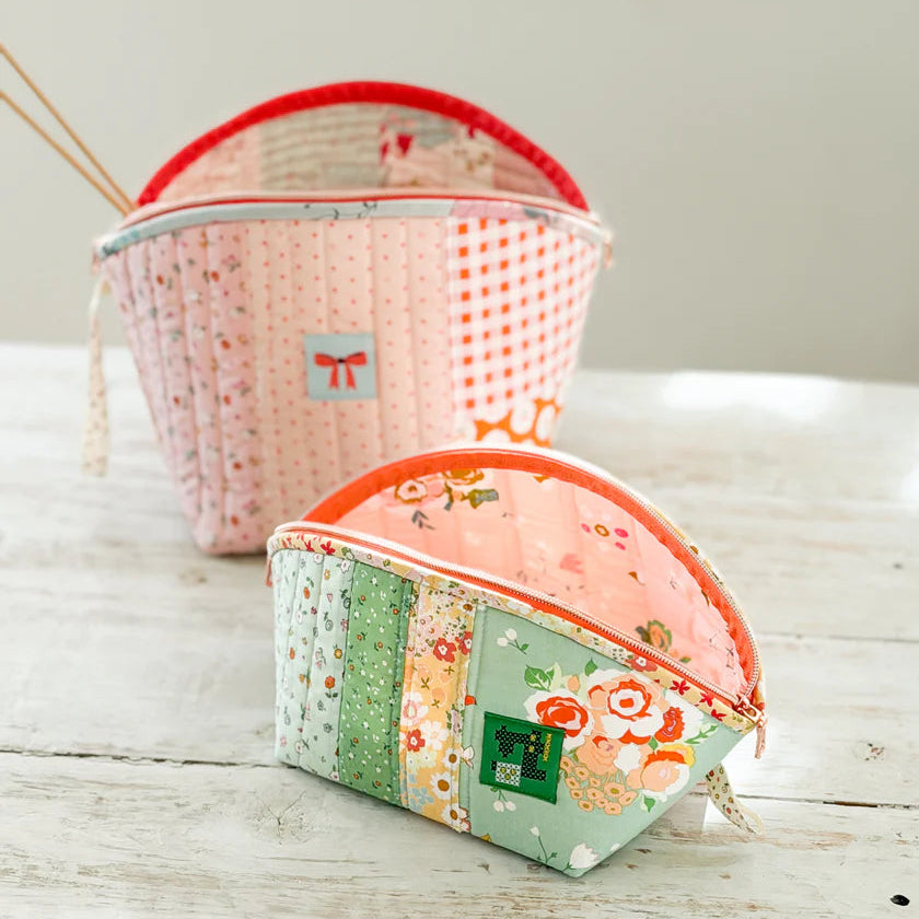 Two fabric pouches with floral patterns on a wooden surface