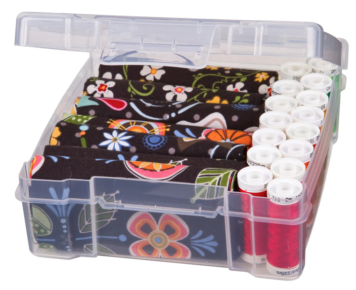 Essentials 6"x6" Plastic Storage Box holding colorful embroidery threads and floral patterned fabric, designed for organizing modern needlework and craft supplies.