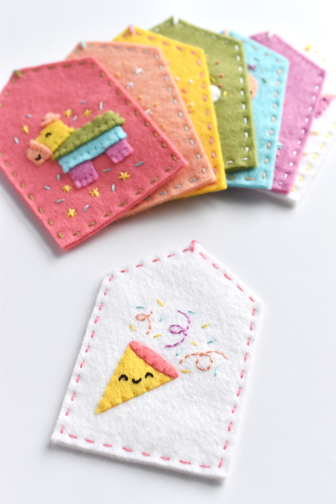 Set of colorful embroidered coasters with cartoon designs on a white background