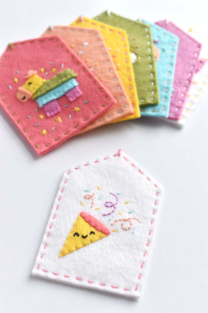Set of colorful embroidered coasters with cartoon designs on a white background
