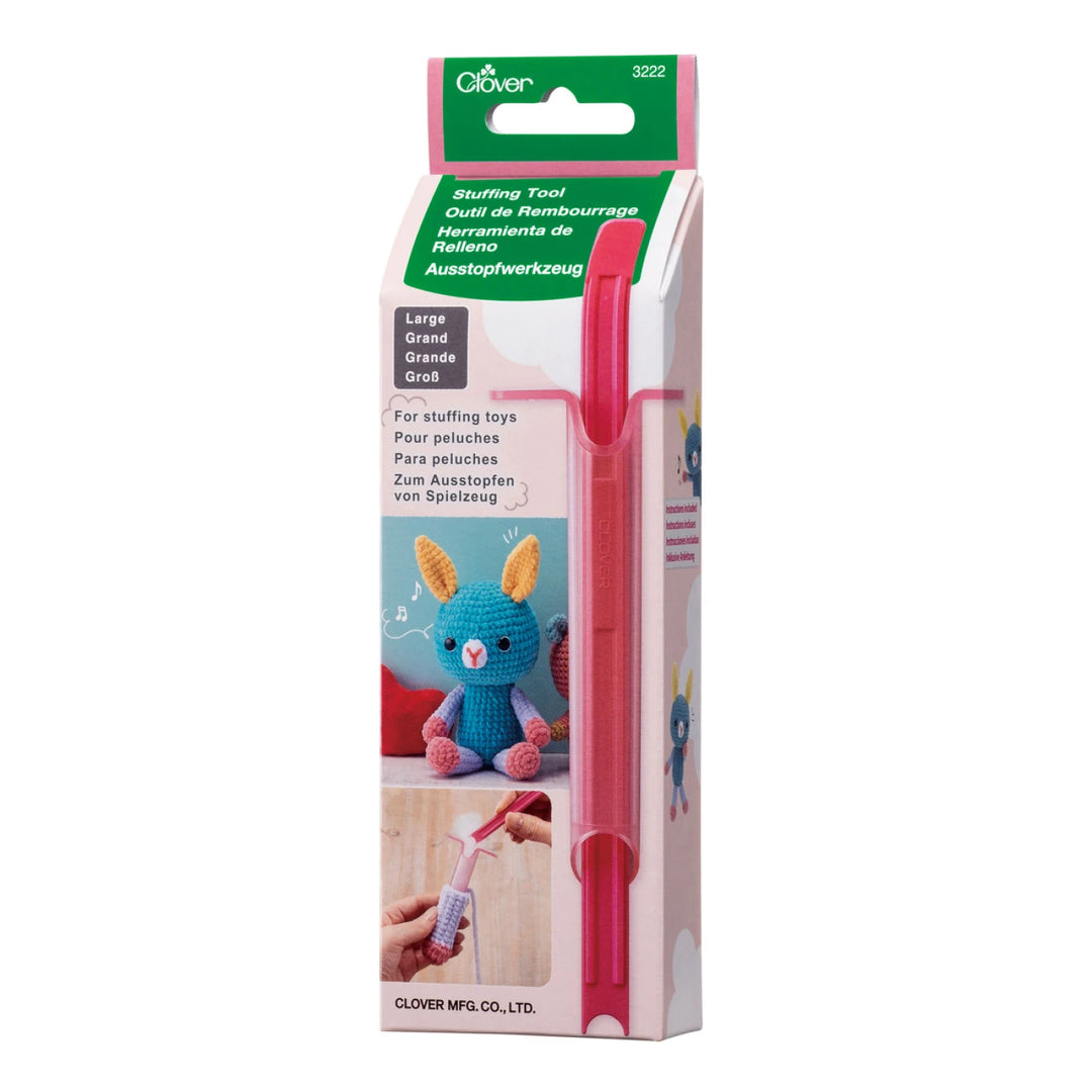 Tube & Plunger Style Stuffing Tool in pink, designed for stuffing toys and soft crafts, displayed in its packaging featuring a crocheted blue bunny and hands demonstrating usage.