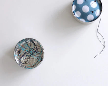 Artisan Made Japanese Pin Cushion featuring a unique design with colorful embroidery thread wrapped around a fabric-covered base, perfect for modern needlework and sewing projects.