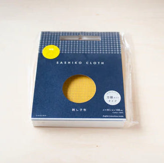 Half-Yard 5mm Straight Line Grid Sashiko Sampler in mustard yellow, packaged Sashiko cloth ideal for Japanese craft supplies and modern needlework projects.