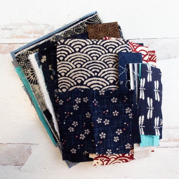 Boro Fabric Scrap Box (8 oz) featuring assorted fabric pieces with traditional Japanese patterns in blue, beige, brown, and red tones, ideal for sewing and quilting projects.