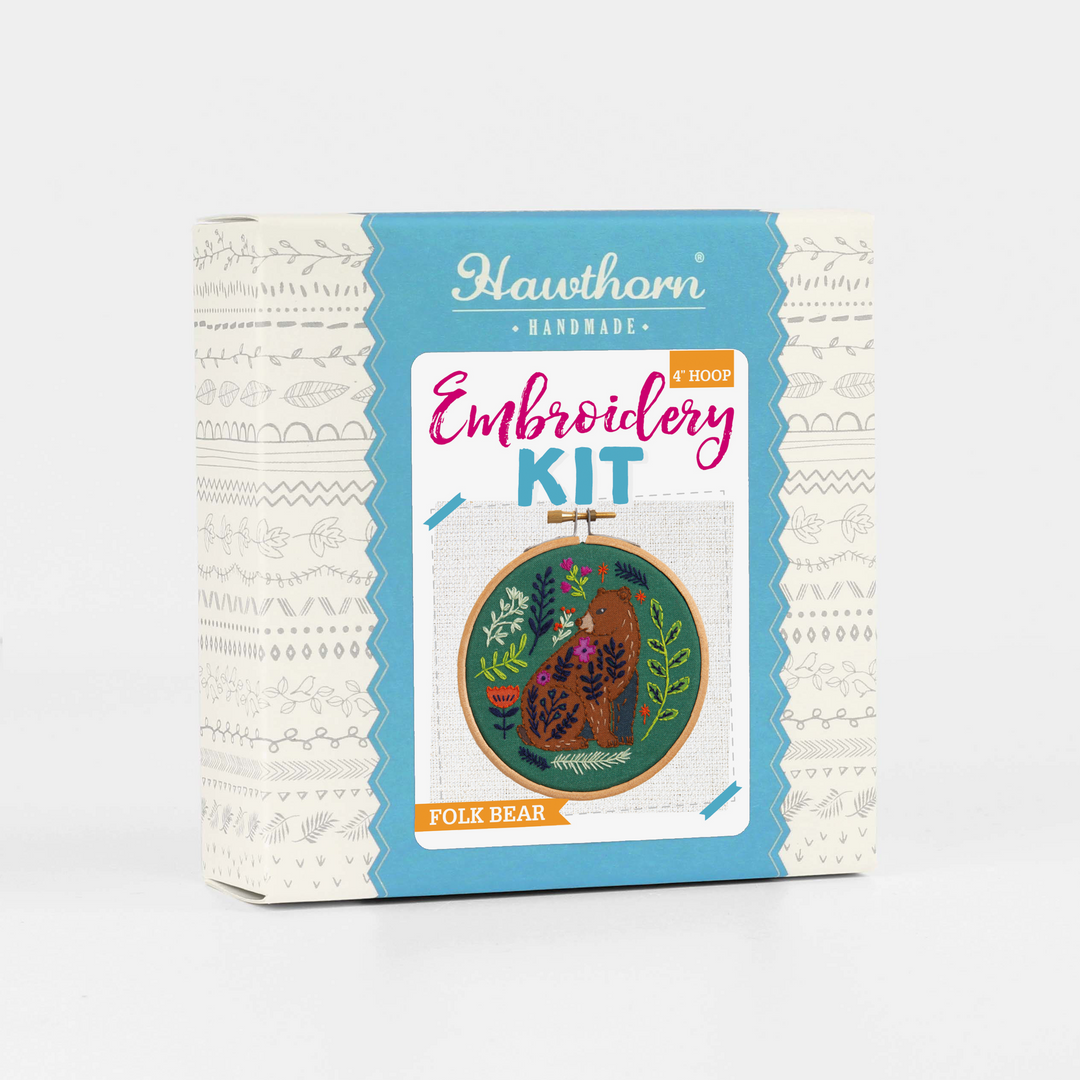 Embroidery kit packaging with bear design on a white background