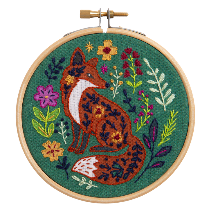 Embroidery hoop with a fox and floral design on a green background