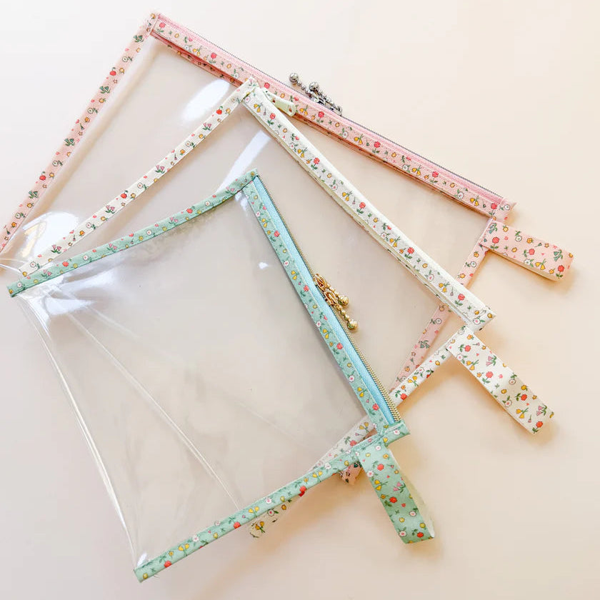 Set of three floral-patterned vinyl project bags on a beige background
