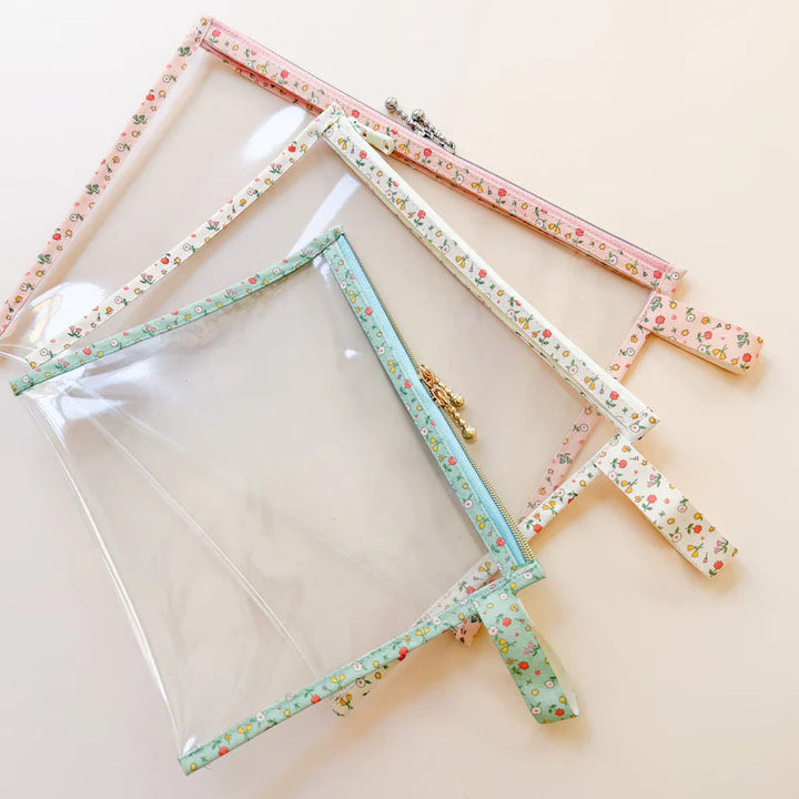 Set of three floral-patterned vinyl project bags on a beige background
