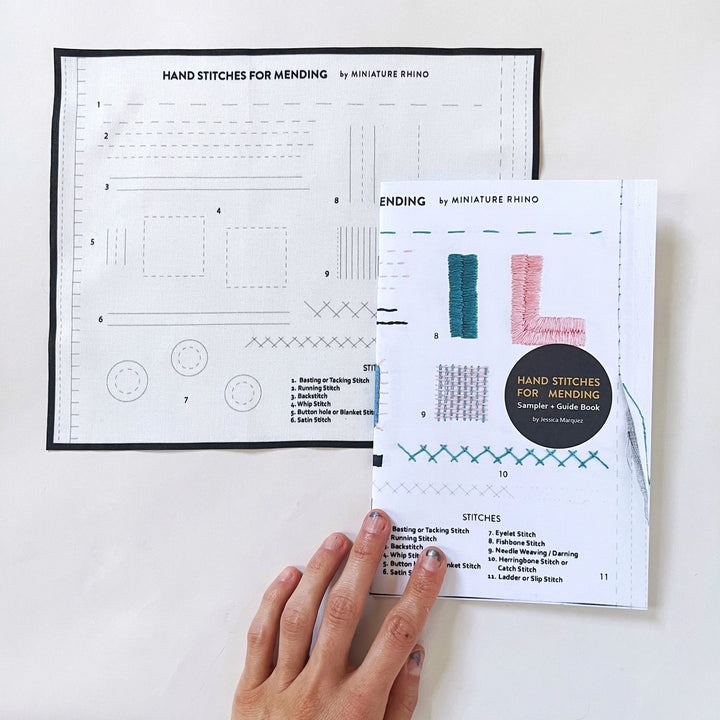 Hand Stitches for Mending Sampler & Booklet showing a cloth with different mending stitch patterns and a guide book with colorful embroidered stitch examples, ideal for modern needlework enthusiasts.