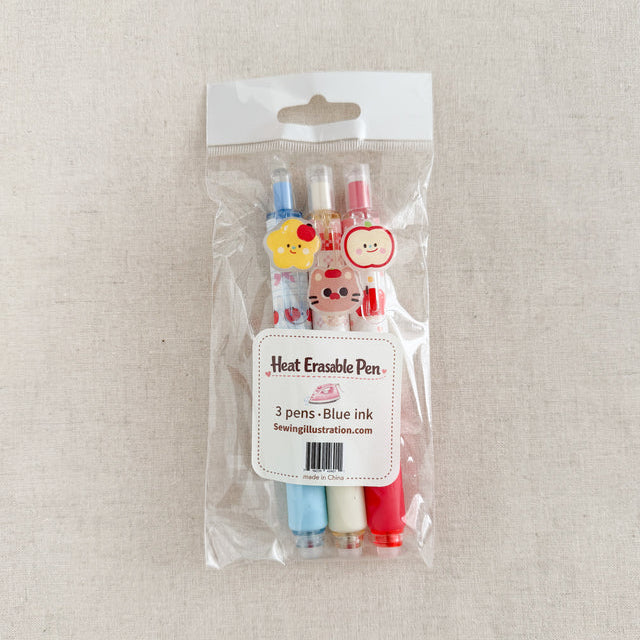 Packaged set of three heat erasable pens with cartoon character caps on a beige background