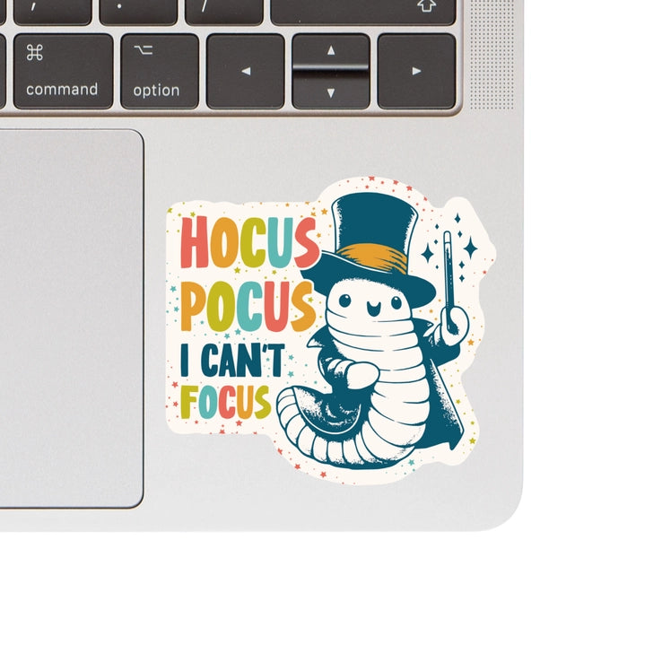 Hocus Pocus Focus Vinyl Sticker with a whimsical cartoon caterpillar wearing a top hat and holding a magic wand, colorful text, perfect for modern needlework and craft enthusiasts.
