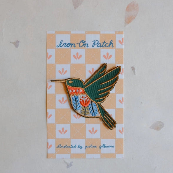 Hummingbird Embroidered Iron-on Patch featuring colorful detailed stitching with green, orange, and blue thread on a decorative backing card, ideal for modern needlework projects.