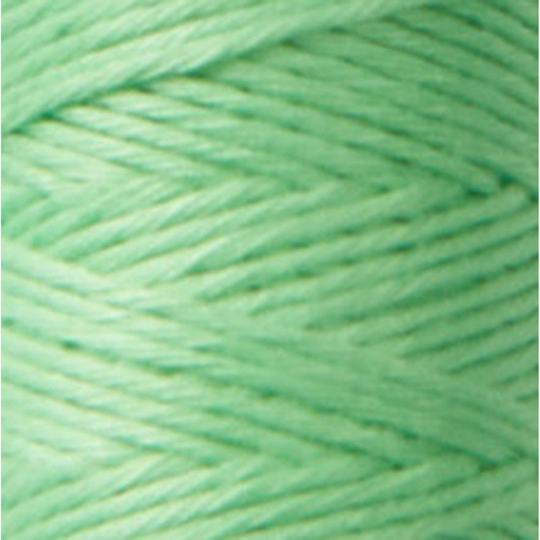 Close-up of soft pistachio green thread in a tightly wound skein, showcasing the smooth texture of Cosmo Hidamari Sashiko Thread - Pistachio (#27) for Japanese craft supplies and embroidery.