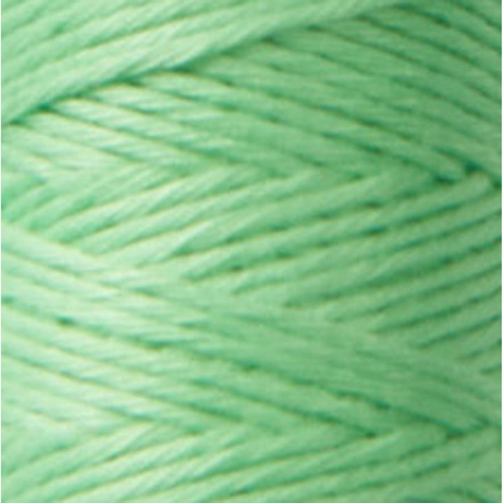 Close-up of soft pistachio green thread in a tightly wound skein, showcasing the smooth texture of Cosmo Hidamari Sashiko Thread - Pistachio (#27) for Japanese craft supplies and embroidery.