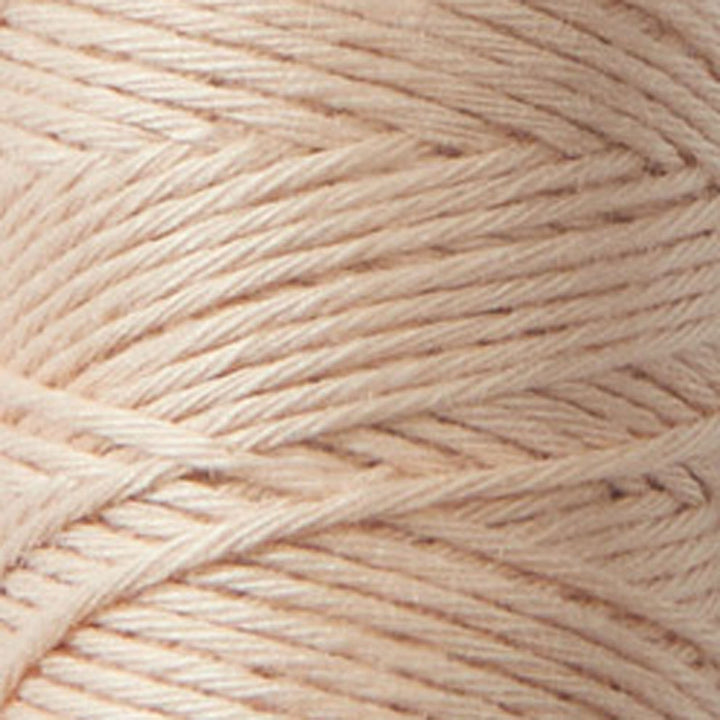 Close-up of tightly wound soft peach-colored Cosmo Hidamari Sashiko Thread - Peach Fuzz (#33) ideal for Japanese craft supplies and modern needlework projects.
