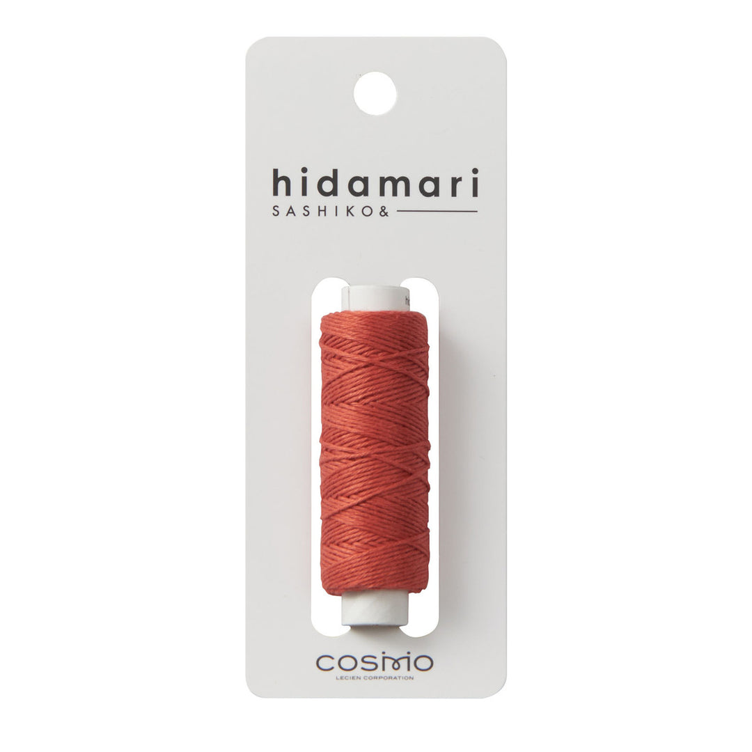 Cosmo Hidamari Sashiko Thread - Burnt Persimmon (#34) displayed on a white card with simple branding, showcasing vibrant reddish-orange thread ideal for sashiko and modern needlework projects.