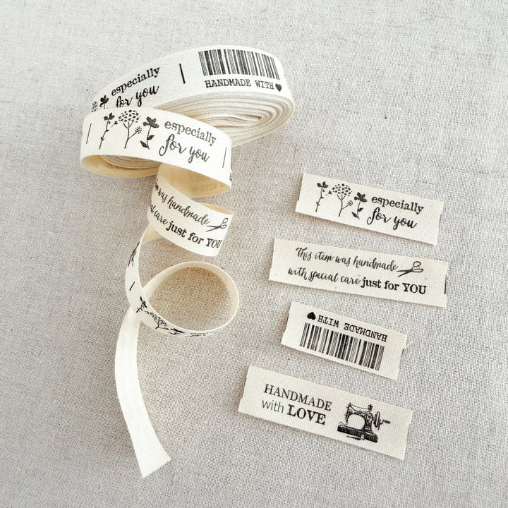 Roll of ribbon with printed labels on a gray fabric background