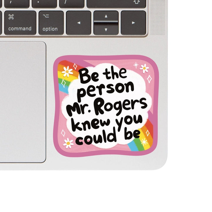 Mr. Rogers Vinyl Sticker with an inspirational quote in playful black text on a white cloud background, framed by a pink border and rainbow accents, ideal for laptops.