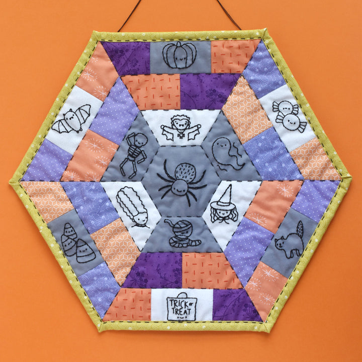 Hexagonal quilt with Halloween-themed designs on an orange background