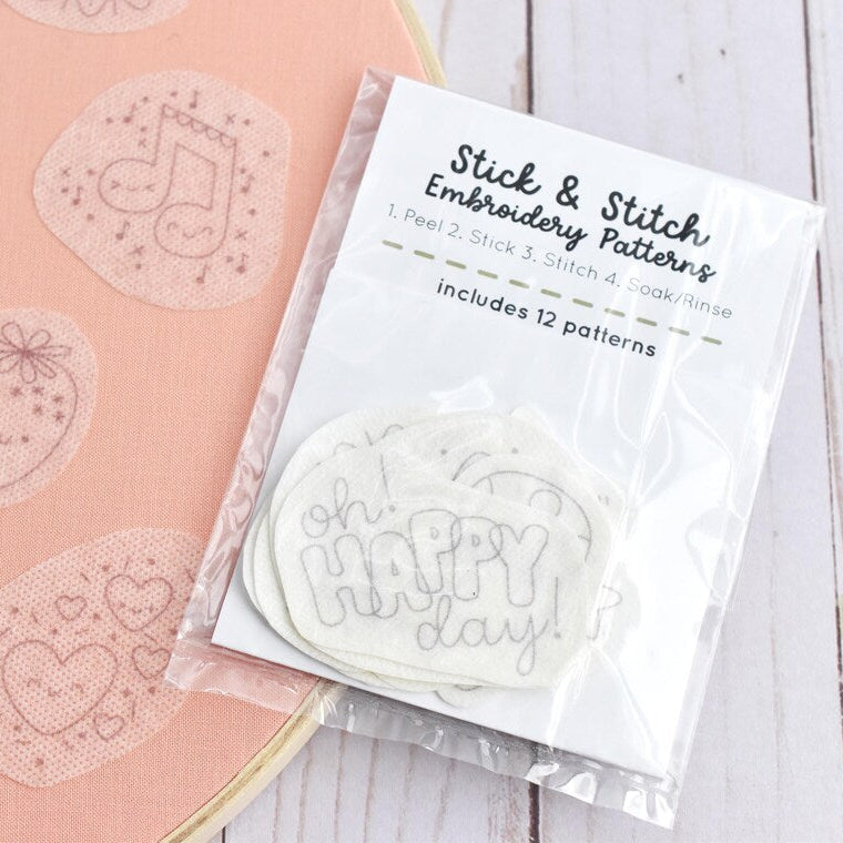 Packaging of stick and stitch embroidery patterns on a pink background with sample designs.