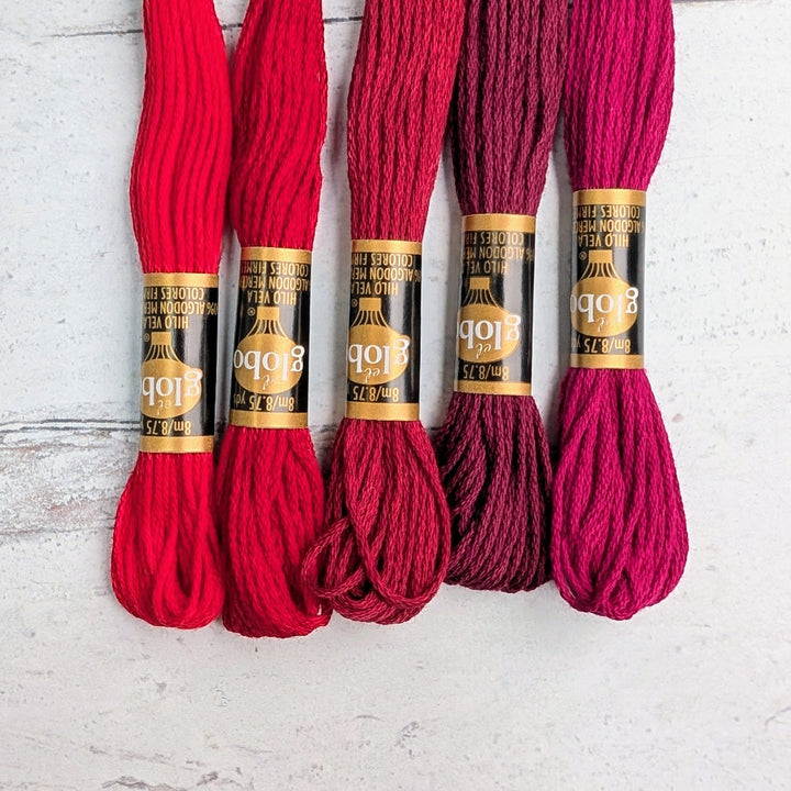 Hilo Vela El Globo Embroidery Thread (8m Skeins) - Reds arranged in a row showing various shades of red embroidery floss for needlework and modern needlework projects.