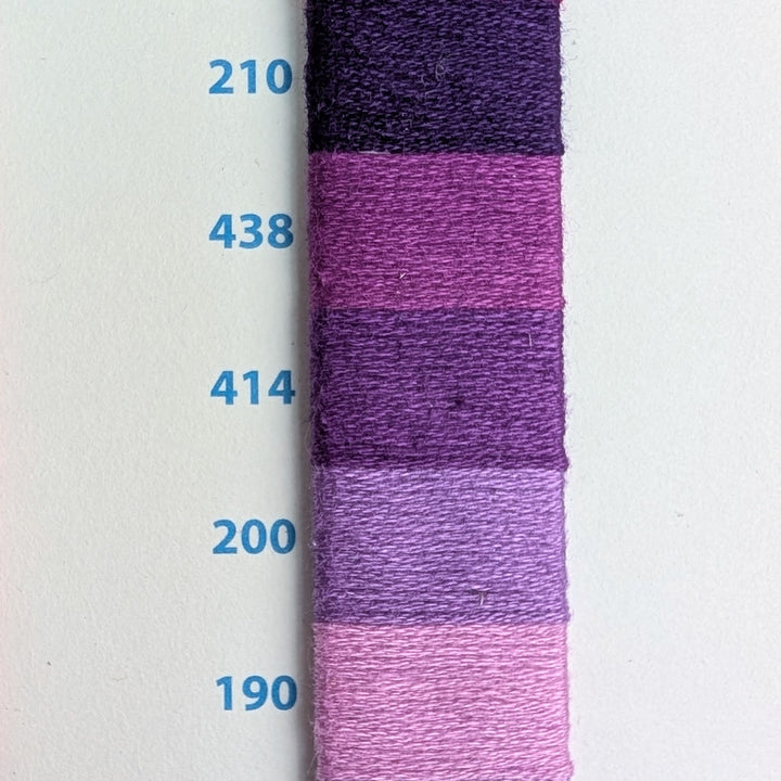 Hilo Vela El Globo Embroidery Thread (8m Skeins) - Purple displayed in a gradient of five shades from dark to light purple on a white background with blue numeric labels, ideal for embroidery and needlework projects.
