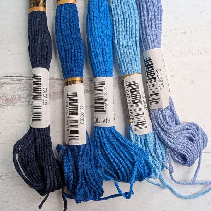 Hilo Vela El Globo Embroidery Thread (8m Skeins) -Blue in various shades, neatly arranged on a white surface, ideal for modern needlework and Japanese craft supplies.