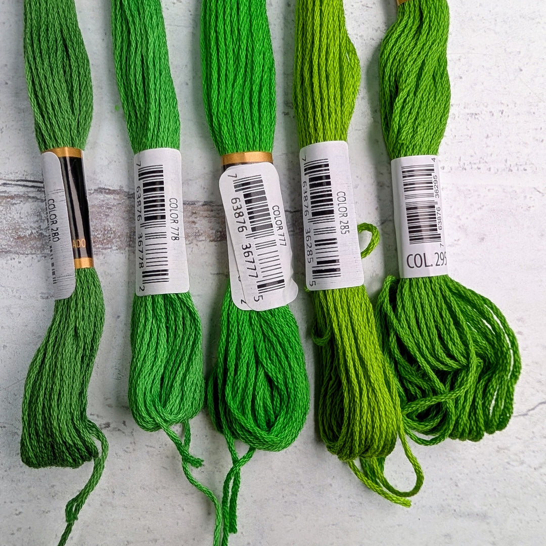 Hilo Vela El Globo Embroidery Thread (8m Skeins) - Bright Green in various shades, arranged side by side on a light surface, ideal for cross stitch, sashiko, and modern needlework projects.