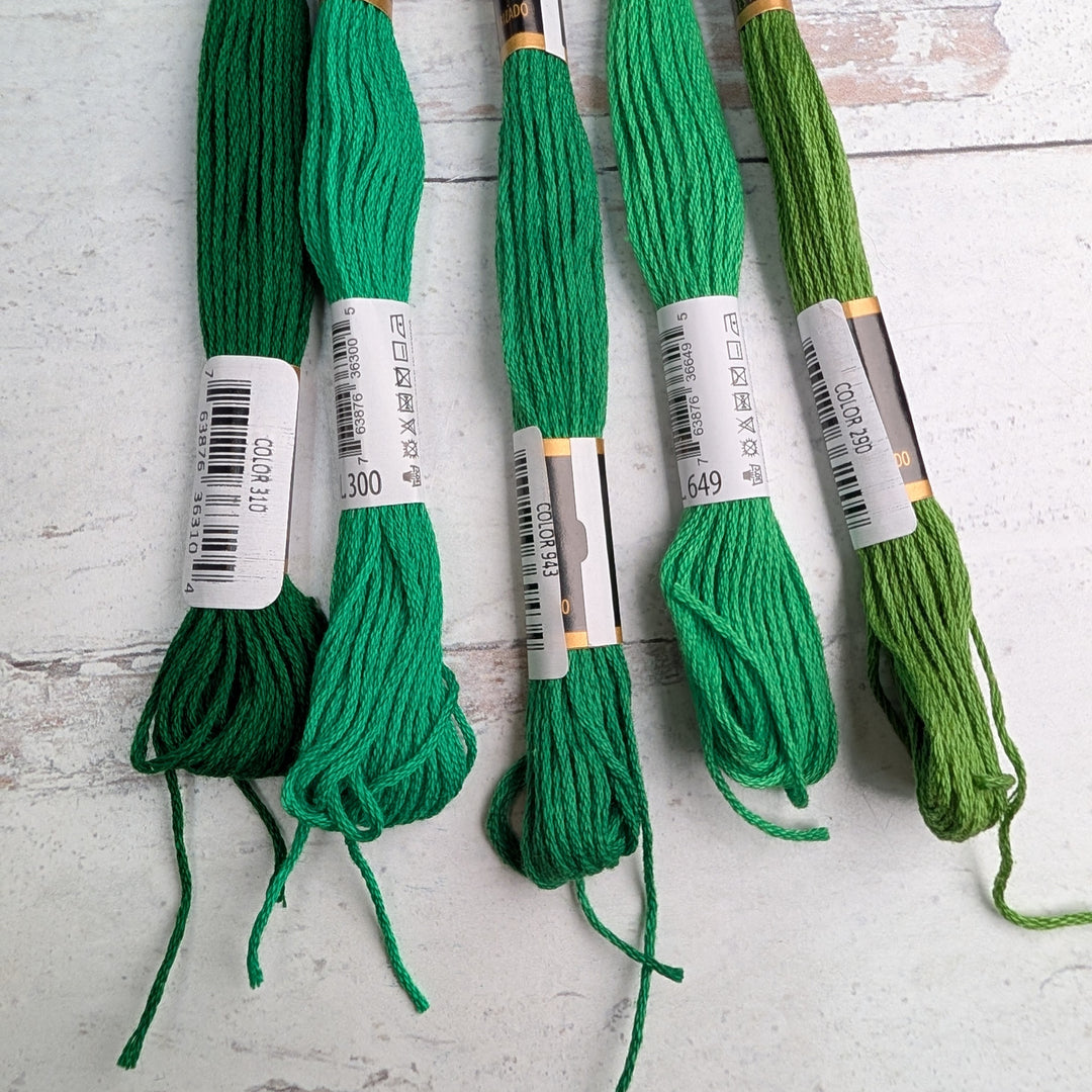 Hilo Vela El Globo Embroidery Thread (8m Skeins) - Green in various shades displayed on a light wooden surface, ideal for Japanese craft supplies and modern needlework projects.