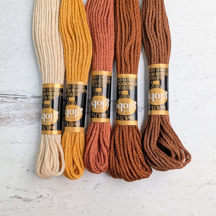 Five skeins of Hilo Vela El Globo Embroidery Thread (8m Skeins) - Brown in varying shades from cream to rich brown, ideal for hand embroidery and modern needlework.