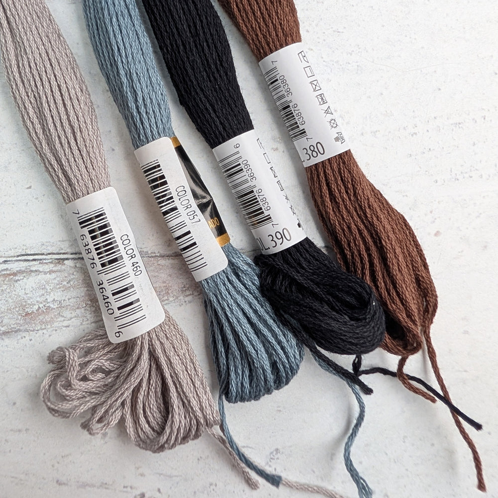 Four skeins of Hilo Vela El Globo Embroidery Thread (8m Skeins) - Neutrals in soft taupe, muted blue, deep black, and rich brown, perfect for modern needlework and Japanese craft supplies.