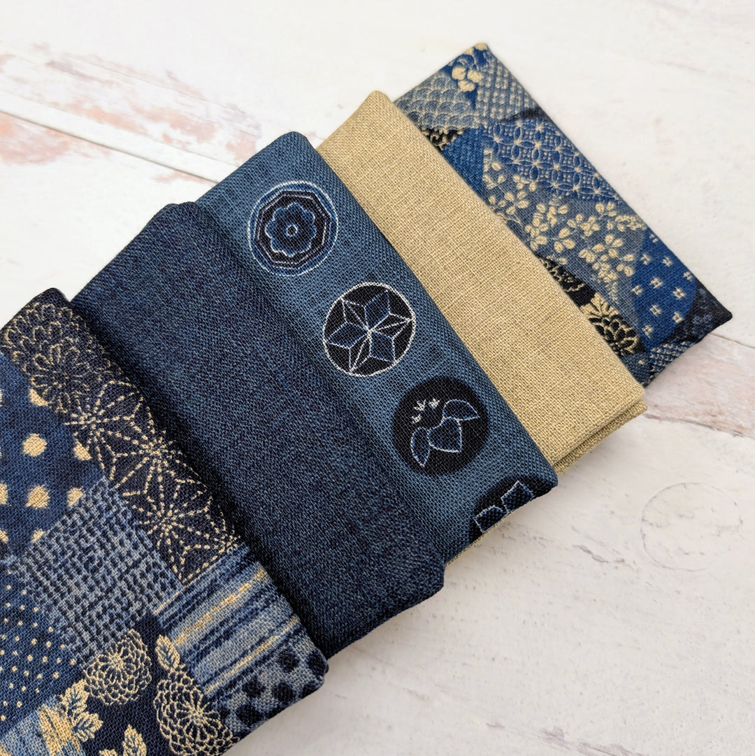 Homespun Rustic Weave Fat Quarter Bundle featuring a selection of blue and beige fabrics with traditional patterns and textures, perfect for modern needlework and sewing projects.
