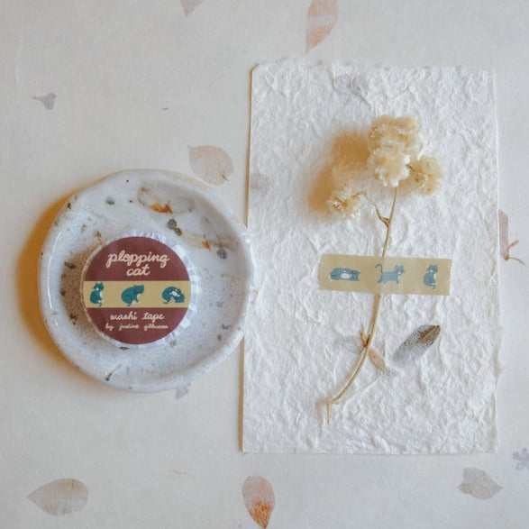 Plopping Cat Washi Tape displayed on textured paper with dried flowers, featuring cute blue cat illustrations, perfect for Japanese stationery and modern needlework projects.