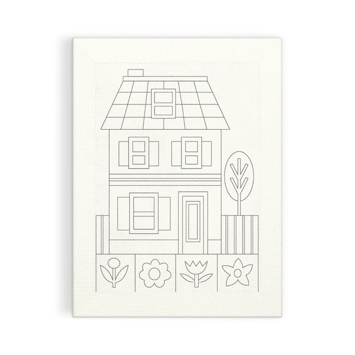 Cozy Cottage Punch Needle Kit featuring a simple line drawing of a two-story house with windows, door, fence, tree, and four stylized flowers on fabric for needlework.