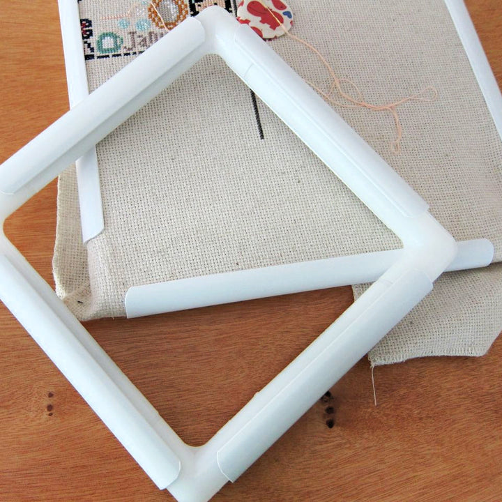Plastic Qsnap frame assembled and laying on top of a cross stitch project that is in another qsnap frame