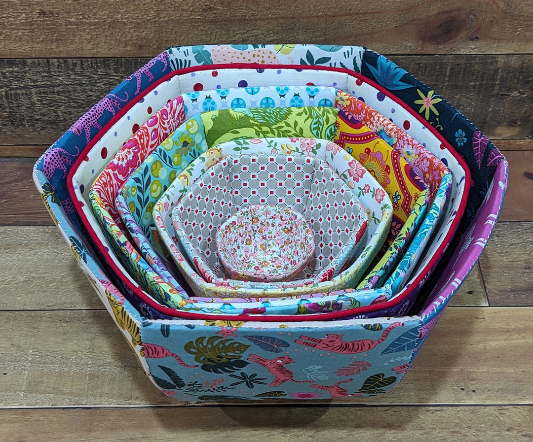 Set of nested fabric bowls featuring vibrant, patterned quilting designs made using the English Paper Piecing Bowls Pattern - The Goodness Bowl, ideal for modern needlework and craft storage.