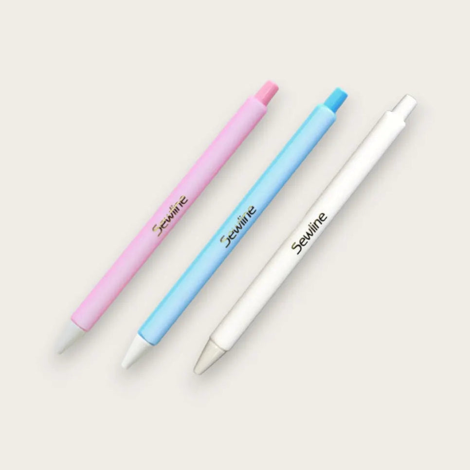 Sewline Fabric Click Pencils in Pink, Blue, White on a beige background