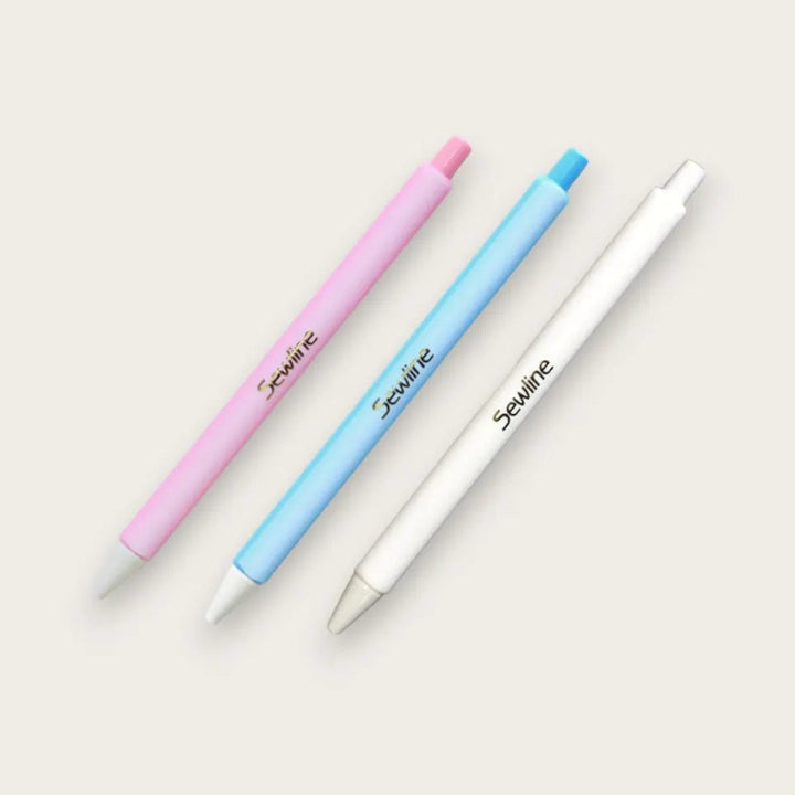Sewline Fabric Click Pencils in Pink, Blue, White on a beige background