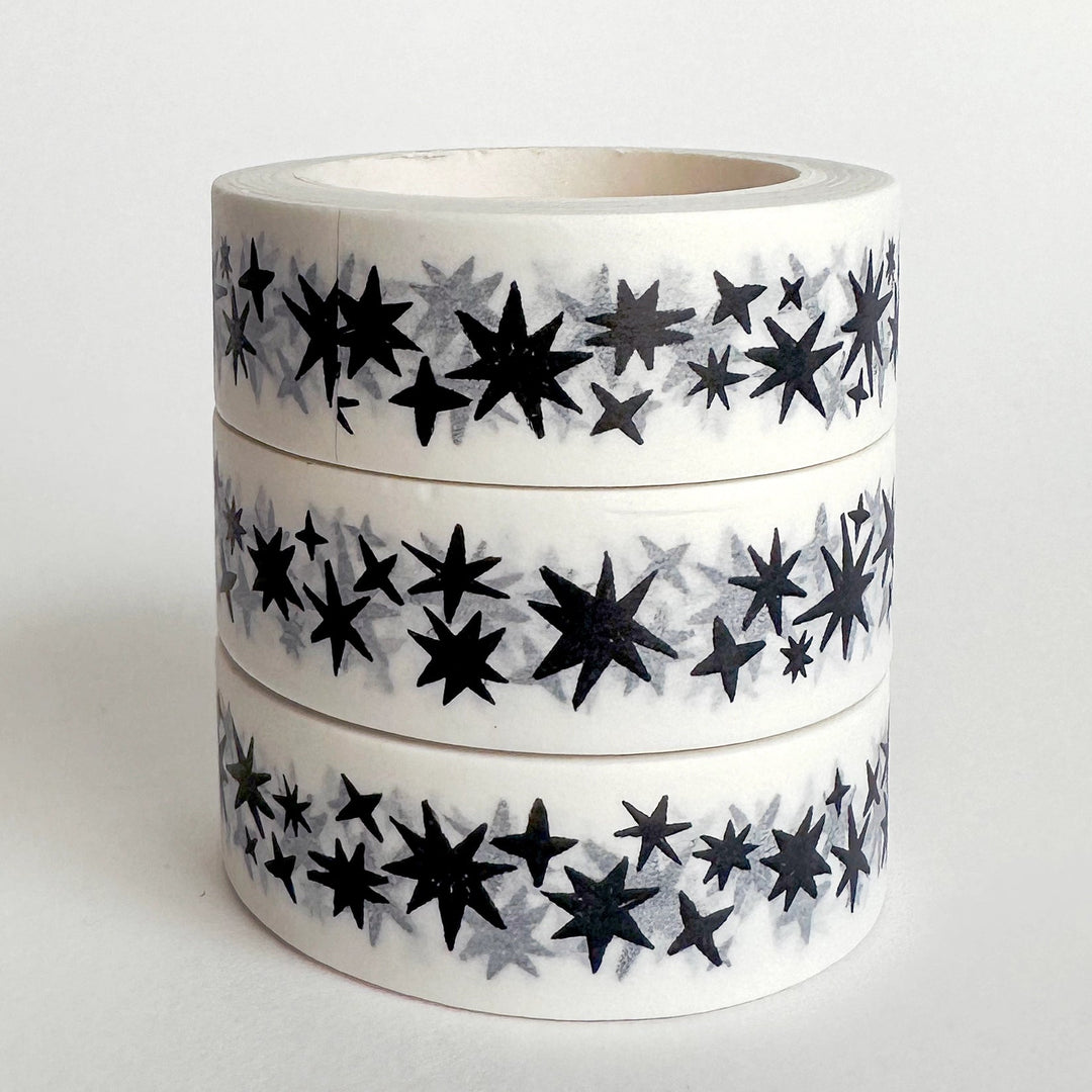 Three rolls of tape with black star pattern on a white background