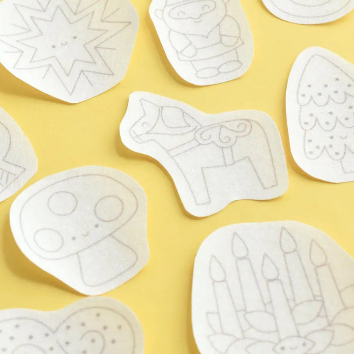 White cookie cutters with various shapes on a yellow background