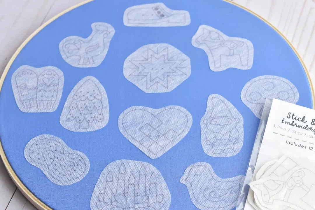 Embroidery hoop with pre-designed embroidery patterns on a blue fabric background