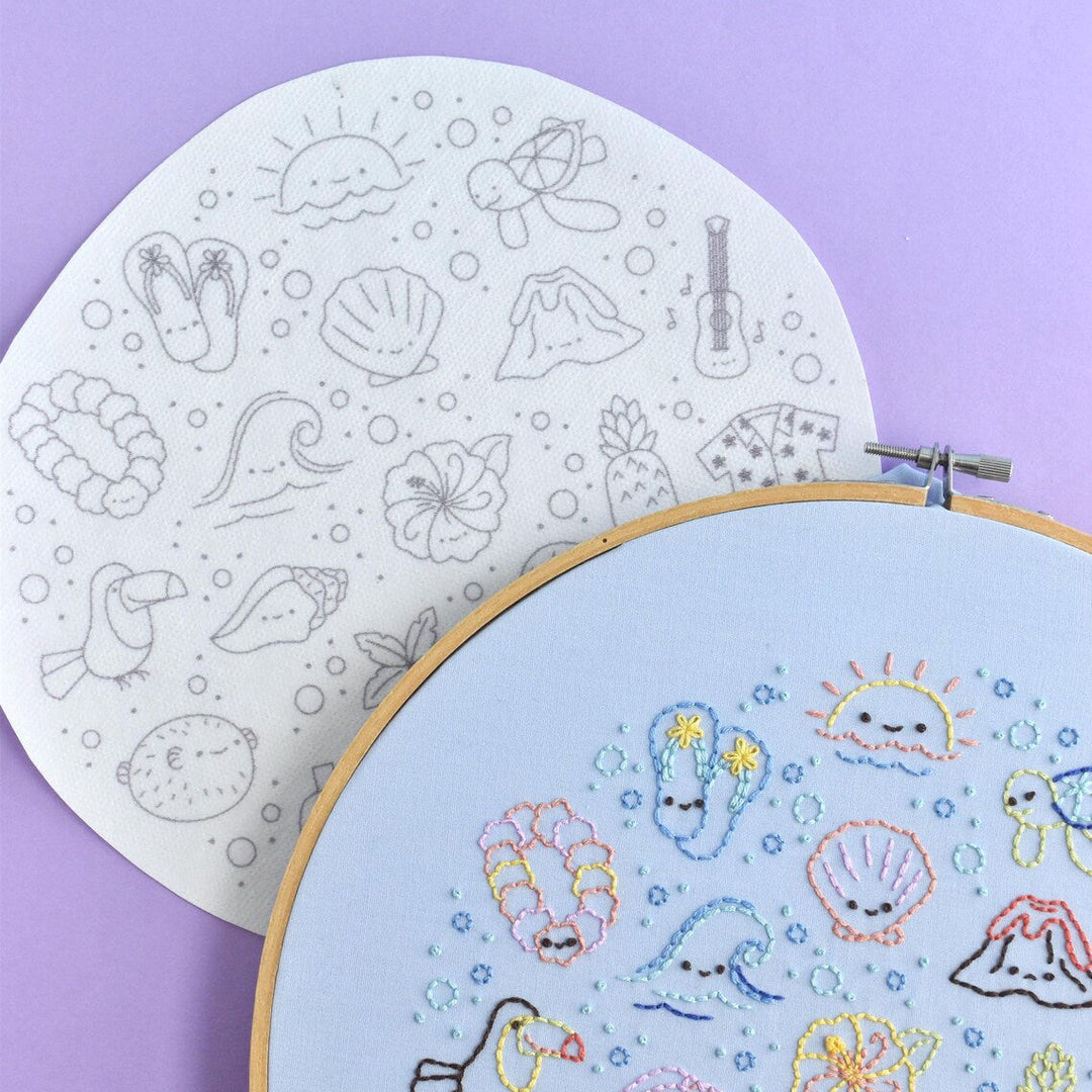 Embroidery hoop with colorful sea-themed designs on a light purple background