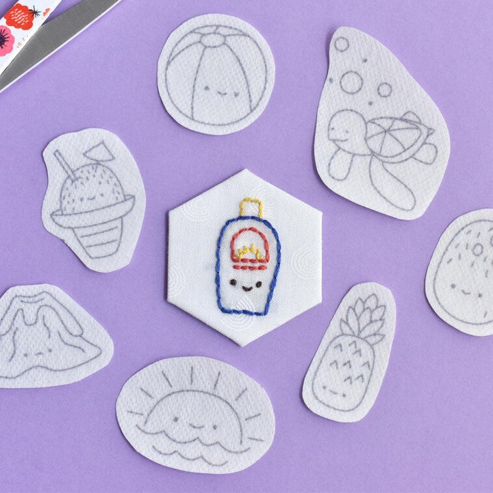 Embroidered patches on a purple background with scissors