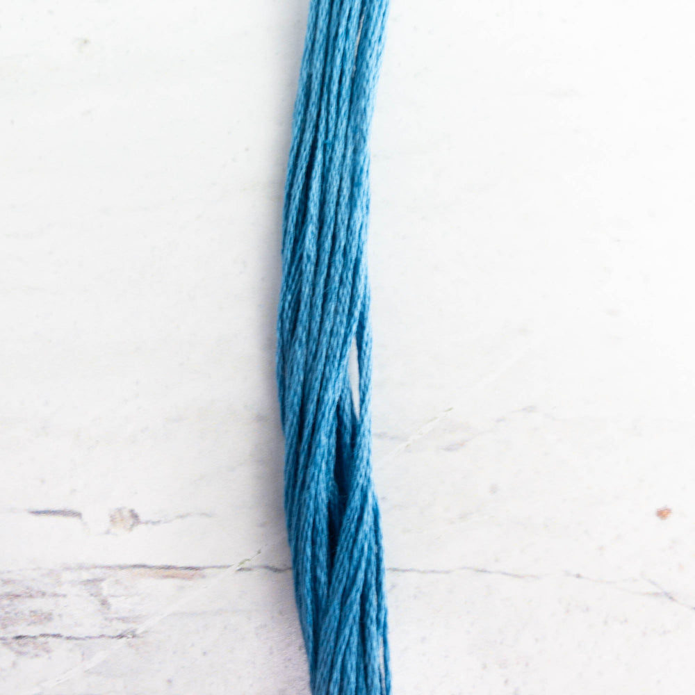 A close-up of Weeks Dye Works Hand Over Dyed Embroidery Floss - Bluecoat Blue (6550) in a rich blue shade, ideal for hand embroidery, cross stitch, and modern needlework projects.