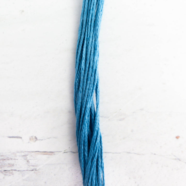 A close-up of Weeks Dye Works Hand Over Dyed Embroidery Floss - Bluecoat Blue (6550) in a rich blue shade, ideal for hand embroidery, cross stitch, and modern needlework projects.